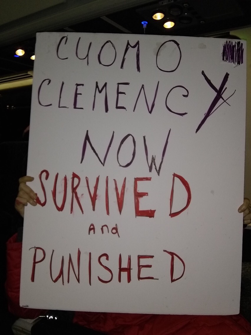 a sign reading: Cuomo Clemency Now, Survived and Punished
